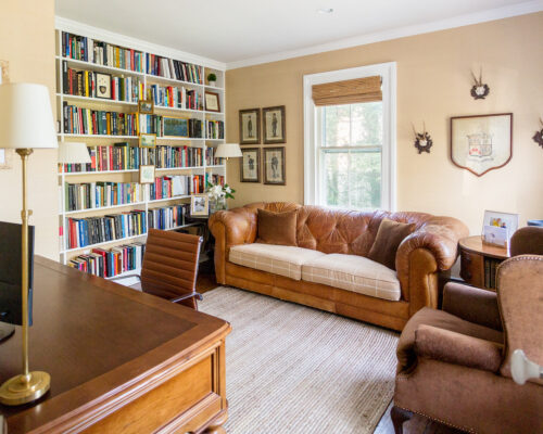 home office leather chesterfield sofa floor to ceiling bookshelves sisal rug